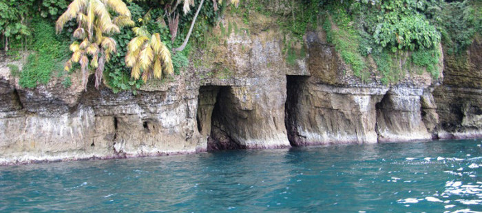 Ein Bootsausflug auf den Bocas del Torros Inseln: Man sieht Felsen mit einem Höhleneingang im Meer