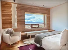 Ein Zimmer des Tierra Patagonia Hotel in Chile: Stilvoll eingerichtet mit Holzboden und Fenster mit Panoramablick