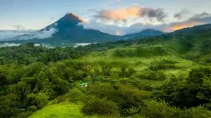 Costa Rica im August - viel Sonne, nur am Nachmittag ziehen wie hier auf dem Bild Schauerolken auf. Man sieht den Vulkan Arenal, um den sich vereinzelt dunkel Wolken legen